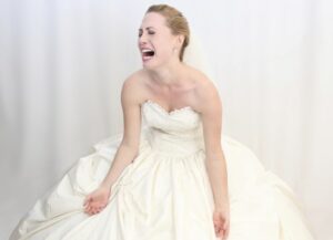 Distraught bride crying with arms outstretched